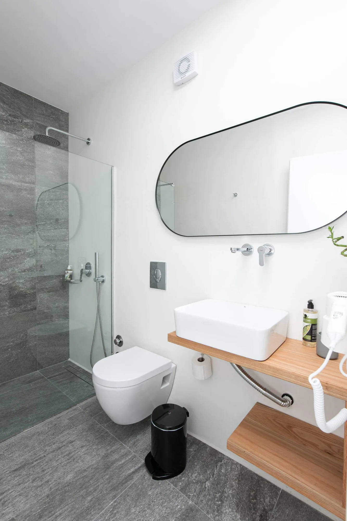 Bathroom with oval mirror and wooden vanity